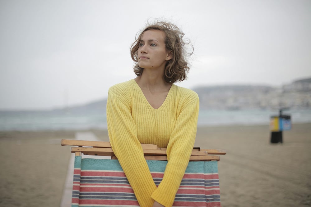 Woman on beach experiencing vacation blues